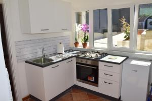 a white kitchen with a stove and a sink at Reginella in Montefiascone