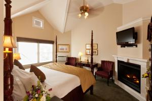 a bedroom with a bed and a fireplace and a tv at Crowne Pointe Historic Inn Adults Only in Provincetown