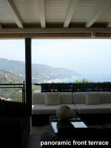 un soggiorno con divano bianco e una grande finestra di casagratia a Taormina