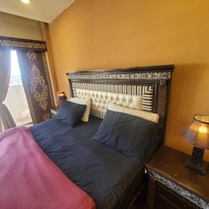 1 dormitorio con 1 cama con cabecero y lámpara en CosmoStay Islamabad, Bahria Town, en Rawalpindi