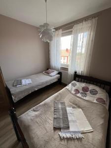 two beds in a small room with a window at Apartament Orzysz in Orzysz
