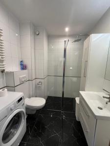 a bathroom with a washing machine and a sink at Apartament Orzysz in Orzysz