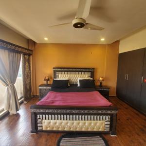 a bedroom with a large bed with a red blanket at CosmoStay Islamabad, Bahria Town in Rawalpindi