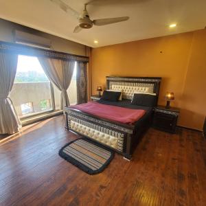 Un dormitorio con una cama grande y una ventana en CosmoStay Islamabad, Bahria Town, en Rawalpindi