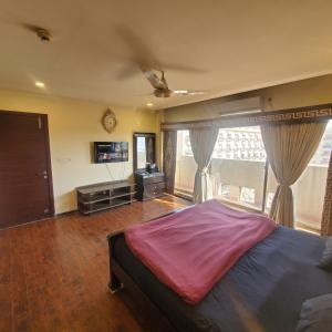 1 dormitorio con cama grande y ventana grande en CosmoStay Islamabad, Bahria Town, en Rawalpindi