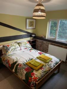 sypialnia z łóżkiem z dwoma żółtymi ręcznikami w obiekcie High Barn w mieście Thursley