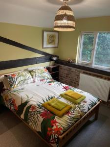 1 dormitorio con 1 cama con 2 toallas amarillas en High Barn, en Thursley