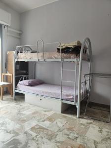 2 łóżka piętrowe w pokoju z podłogą wyłożoną kafelkami w obiekcie travel to meet new friends new loves - age limit 18-40 - checkin Via Roma 59A w mieście Palermo