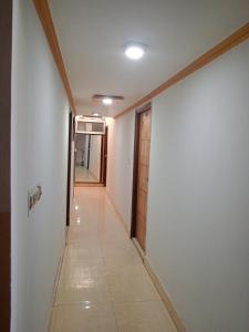 um corredor com paredes brancas e um corredor com uma porta em Hotel Swarajya Palace em Agra