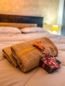 una manta y un regalo en una cama en Guest House Isabel Pinto, en Santa Maria di Sala