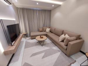 a living room with a couch and a television at Elite House in Taif