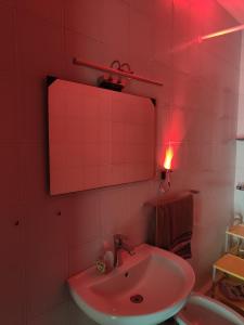 a pink bathroom with a sink and a red light at travel to meet new friends new loves - age limit 18-40 - checkin Via Roma 59A in Palermo