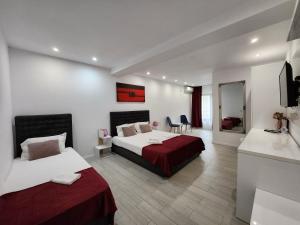 a hotel room with two beds and a television at Analeya in Eforie Nord