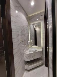 W łazience znajduje się umywalka i lustro. w obiekcie Elite House w mieście Taif