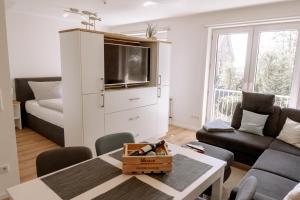 ein Wohnzimmer mit einem Sofa und einem TV in der Unterkunft Ferienwohnung AHOI in Norderney