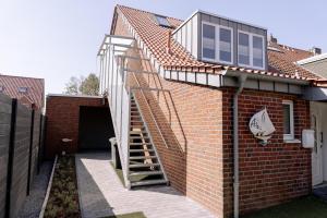eine Treppe, die in ein Backsteingebäude mit einem Fenster führt in der Unterkunft Ferienwohnung AHOI in Norderney