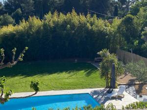 a backyard with a swimming pool and a lawn at Chez Pat et Dom in Aix-en-Provence
