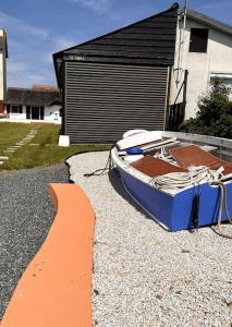 a boat sitting on the gravel in front of a house at Chaumière côtière: plage à 500m,à deux pas du GR34 in Plérin
