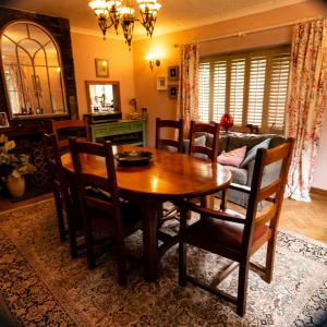 High Barn في Thursley: غرفة طعام مع طاولة وكراسي خشبية
