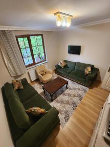 a living room with a green couch and a table at Trend Suite Hotel in Uzungöl
