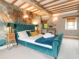 a bedroom with a large bed with a blue couch at Wildersley Farm - The Farm House in Belper