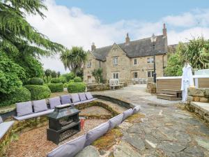 a backyard with a stone house with a fire pit at Wildersley Farm - The Farm House in Belper