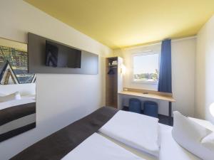ライプツィヒにあるB＆B ホテル ライプチヒ - ノルドのベッドとデスクが備わるホテルルームです。