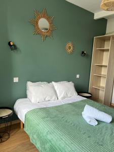 a bedroom with a large bed with a green blanket at Hôtel de la Poste in Coudes