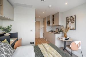 a bedroom with a bed and a small kitchen at En-suite room in London