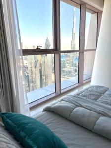 uma cama num quarto com uma grande janela em Fabulous Burj View by Smart Apt no Dubai
