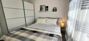 a small bedroom with a bed and a window at Apartman Chilli in Dramalj