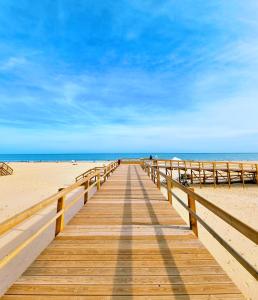 un paseo marítimo de madera que conduce a la playa en Apartamentos Turisticos Alagoa Praia en Altura