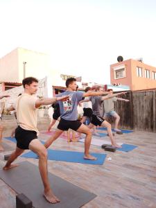 un grupo de hombres en una clase de yoga en Surf hostel Morocco en Tamraght Ouzdar