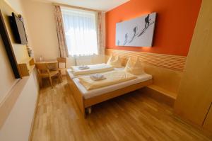 1 dormitorio con 2 camas en una habitación con paredes de color naranja en JUFA Hotel Schladming en Schladming