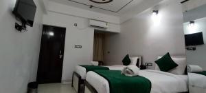 a hotel room with two beds and a television at Hotel Aman Residency in Allahābād