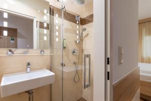 La salle de bains est pourvue d'un lavabo et d'une douche. dans l'établissement Best Western Hotel Strasser, à Graz
