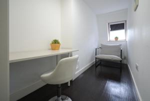 ein weißes Büro mit einem Schreibtisch und einem Stuhl in der Unterkunft Charlotte Street Rooms by News Hotel in London