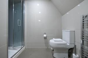 a white bathroom with a toilet and a shower at Charlotte Street Rooms by News Hotel in London +133 photos