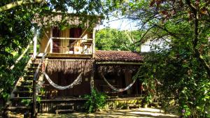 uma casa com uma rede fora dela em Pousada Roy Bonete em Ilhabela