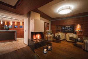 a living room with a fireplace and a couch at Genusshotel Fichtenhof in Grossarl