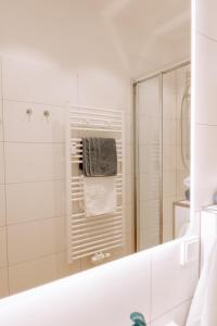 baño blanco con ducha y espejo en Seehus 8, en Norderney