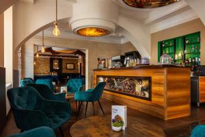 um restaurante com cadeiras azuis e um bar em Best Western Hotel Strasser em Graz