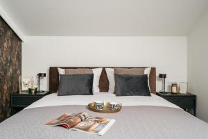 a bed with two magazines and shoes on it at Main Square Apartments by LoftAffair in Krakow