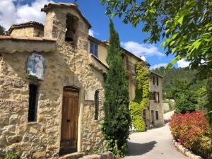 - un vieux bâtiment en pierre avec une porte en bois dans l'établissement Maison de caractère Toudon - Arrière Pays Niçois - Proche Nice, à Toudon