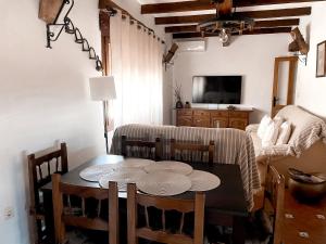 a dining room with a table and a tv at Casa Rural Pernales I in Ruidera
