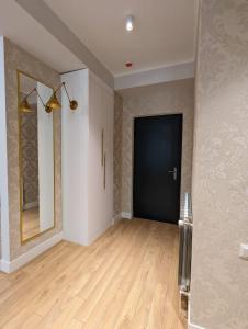 a hallway with a black door and a mirror at Suites In Tbilisi Hilton Apartment in Tbilisi City