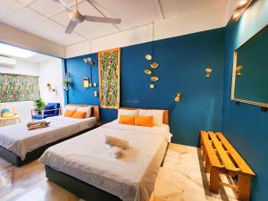 two beds in a room with blue walls at Ipoh Station 18, 4 Bedroom Rainforest LOFT 1 Depan Aeon in Ipoh