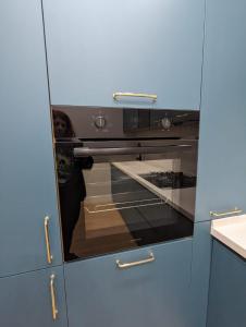 a kitchen with an oven in a blue cabinet at Suites In Tbilisi Hilton Apartment in Tbilisi City