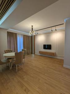 a living room with a table and a tv at Suites In Tbilisi Hilton Apartment in Tbilisi City