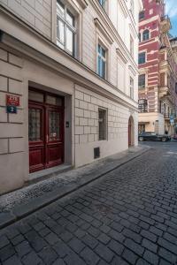 eine leere Straße vor einem Gebäude mit roten Türen in der Unterkunft Naprstek Urban Retreat in Prag